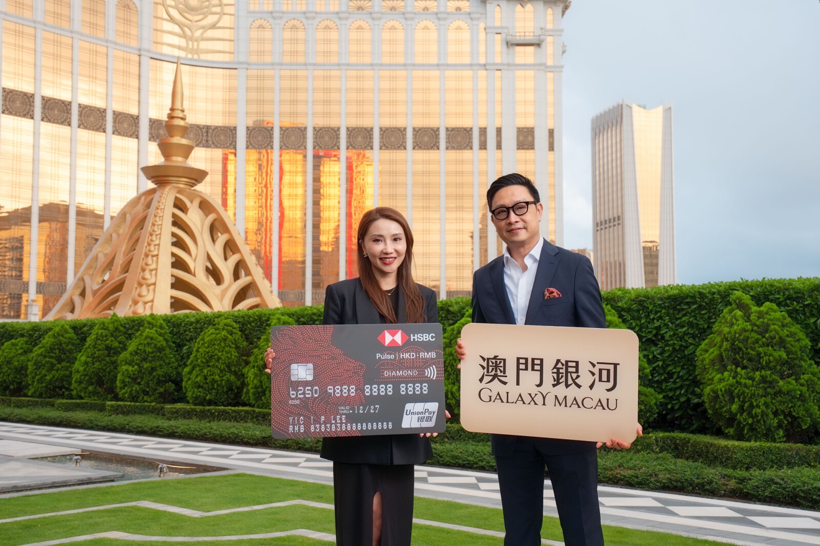 「澳門銀河」与汇丰香港信用卡携手推出星级礼遇，持续升华宾客体验。为隆重其事，银河娱乐集团市场推广及活动策划事务董事谢振国先生与汇丰香港区零售银行及财富管理业务无抵押贷款及卡类业务策略合作及发展主管伍佩怡女士，代表双方管理层特别于“澳门银河 莱佛士”户外花园留影作为启动礼。