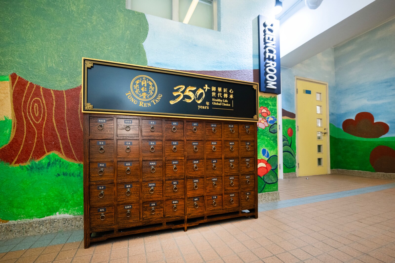 北京同仁堂今年为参与计划的每间学校设置传统中药房常用的「百子柜」，把中医药文化元素带进校园，营造更具中医药文化氛围的学习环境，支持学校延伸健康教育与文化学习。