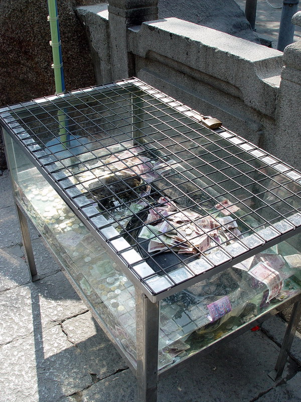 鐵絲網的貢獻箱 攝影：簡時強